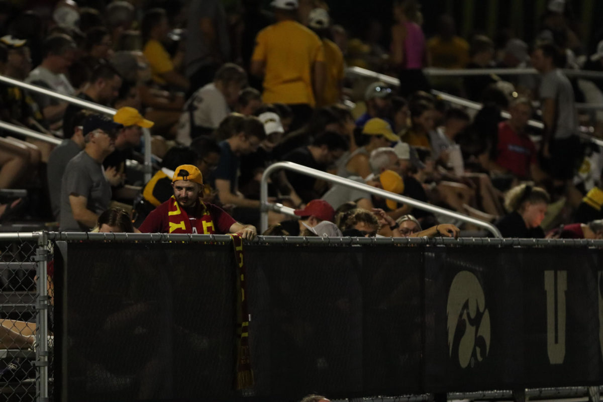 A Iowa State fan tries to get others to rally alongside during the Cy-Hawk soccer game, University of Iowa Soccer Complex, Aug. 24, 2023.