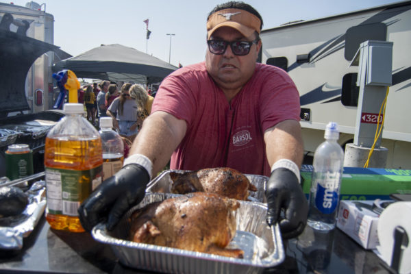 Tyler Chase, the pit boss of the tailgate, pulls out a whole chicken while tailgating before the Iowa Corn Cy-Hawk Series football game on Saturday, Sept. 9, 2023, at the RV Village in Ames.