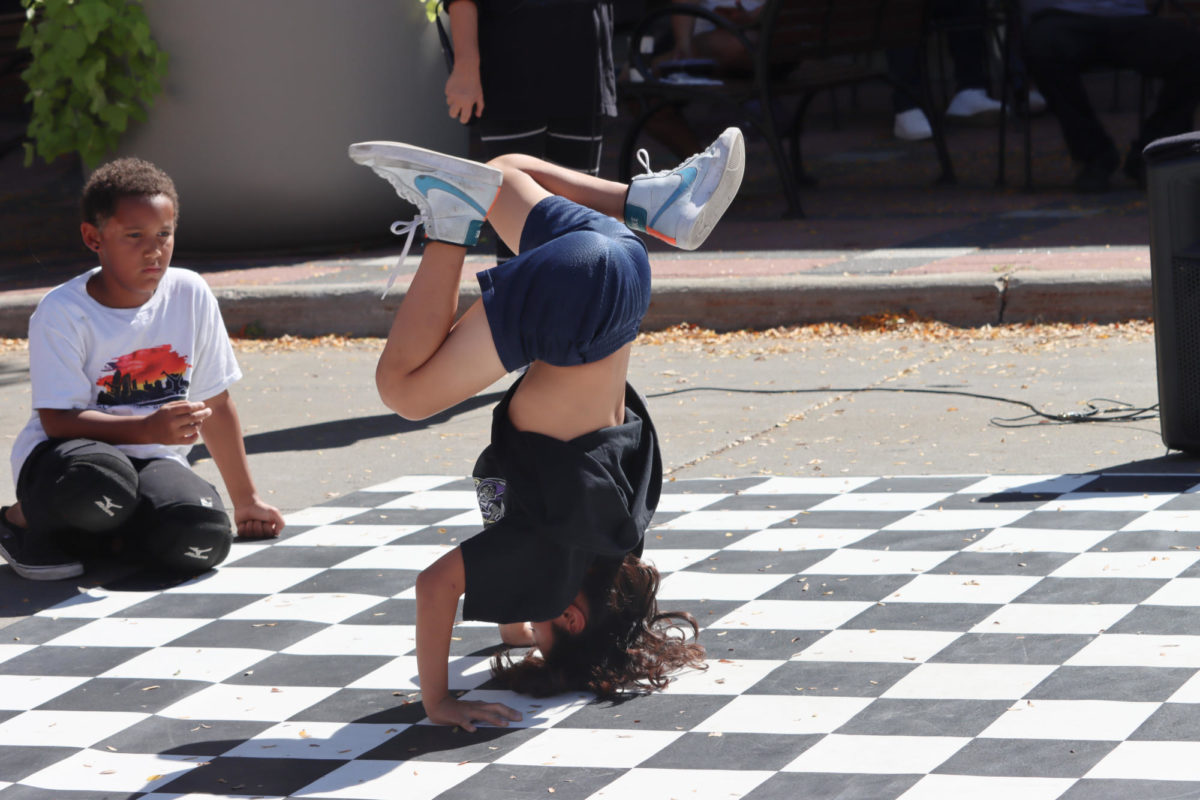 Micah Starwood, age nine, a dancer at DSM Breakerz shows the crowds his headstand tricks at the Octagon Art Festival on Sunday, Sept. 24, 2023. 