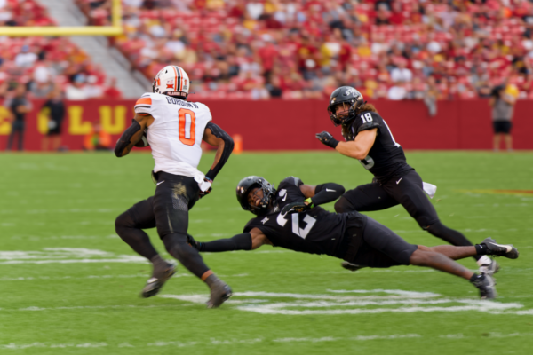 Oklahoma State player evading a tackle from Iowa State players T.J. Tampa and Ben Nikkel in Jack Trice Stadium on Sept, 23. 2023.