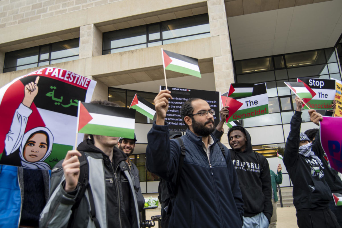 Attendees of the Stand with Gaza gathering hold Palestinian flags and signs on Thursday, Oct. 19, 2023, outside of Parks Library in Ames, Iowa.
