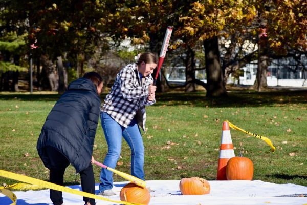 Attendees of the Student Government Expo, smash pumpkins on the front lawn of Curtiss Hall at the first annual gathering, Nov. 9, 2023.