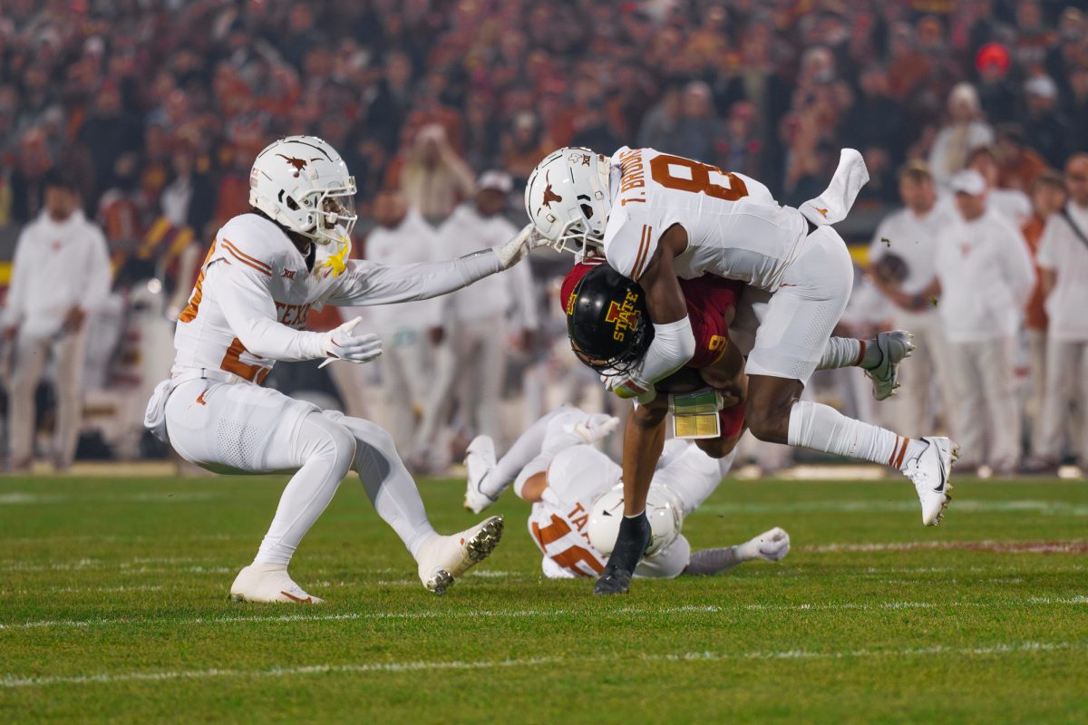 Jayden Higgins of Iowa State being toppled by Texas DB Terrance Brooks on Nov. 18, 2023 during the Iowa State vs. Texas football game in Jack Trice Stadium.