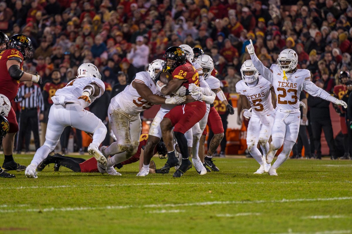 Abu Sama III of Iowa State being pushed to the ground by Texass defensive line during the Iowa State vs. Texas football game on Nov. 18, 2023 in Jack Trice Stadium.