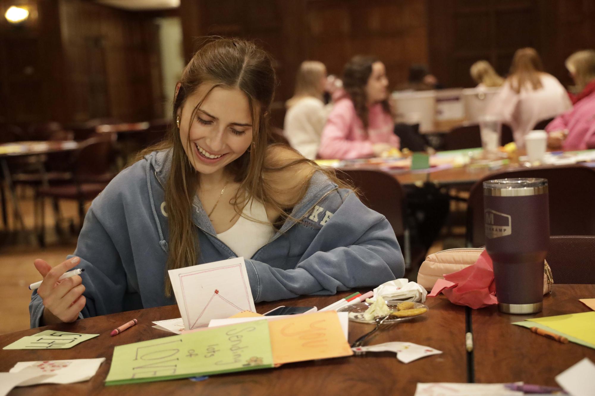 Carly Halstead, a freshman studying kinesiology and health, writes words of encouragement in a hand-made card at the Greetings from Greenlee: A Letters of Love Event 2023 Nov. 28 in the Memorial Union Great Hall.