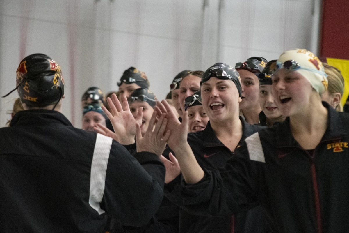 The Iowa State swim and dive team give each other high-fives as their teammates are announced before the meet against Iowa on Friday, Dec. 8, 2023, at Beyer Hall in Ames, Iowa.