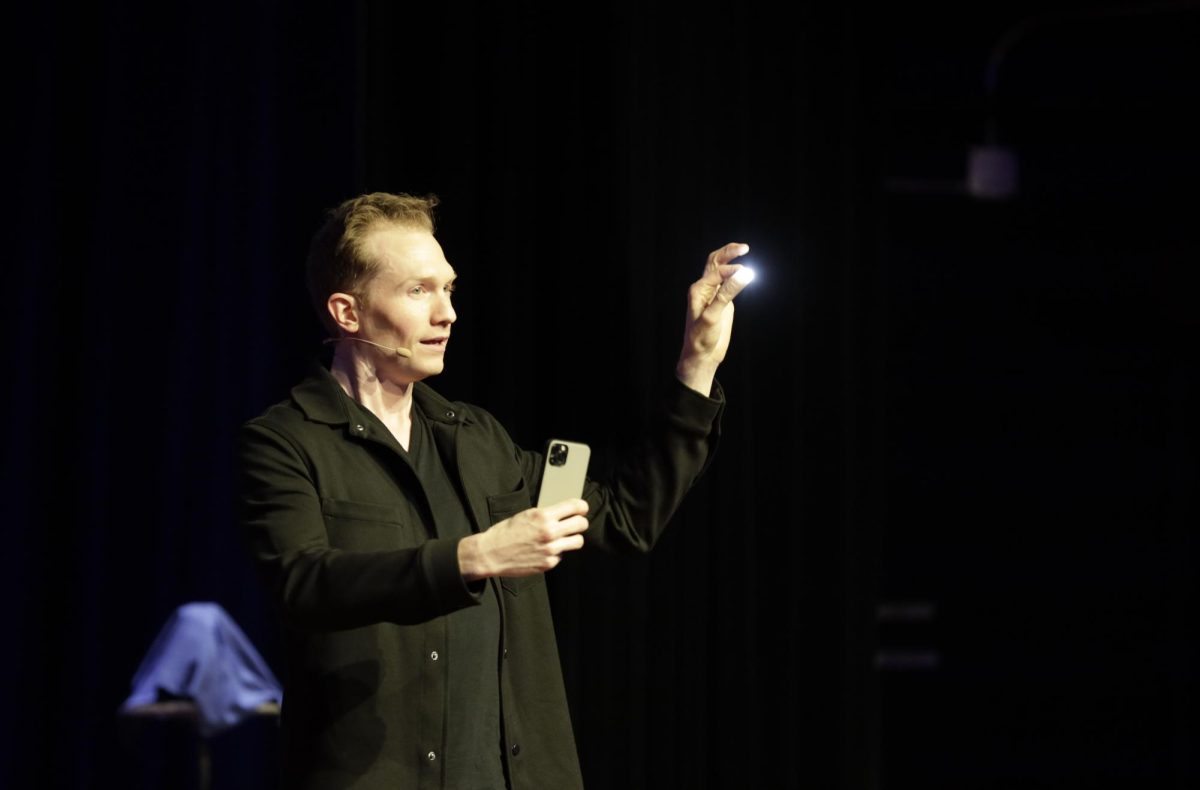 Magician Trigg Watson performs a trick with his phone flashlight at his show in the Memorial Union Great Hall during Winterfest on Friday, Dec. 1, 2023. Watson was a semifinalist on Americas Got Talent this year. 