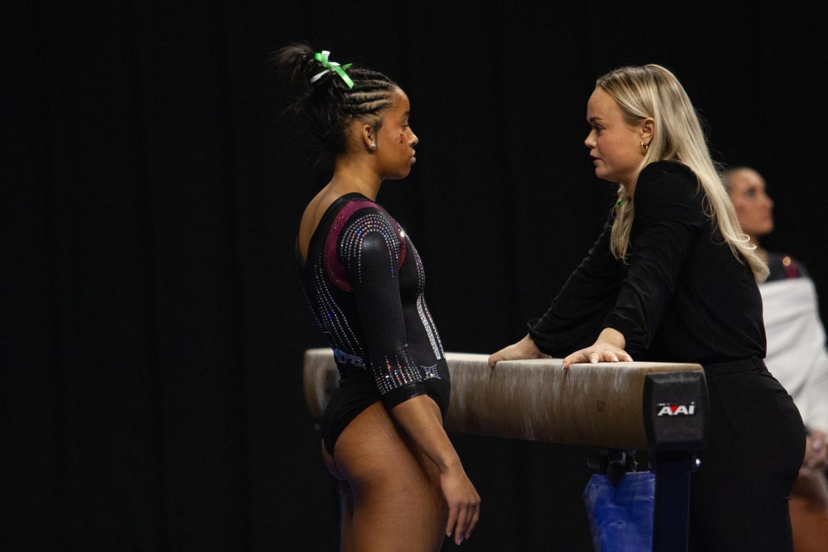 Noelle Adams talking with assistant coach Haylee Young before her run during the Iowa State vs. BYU meet on Jan. 19, 2024.