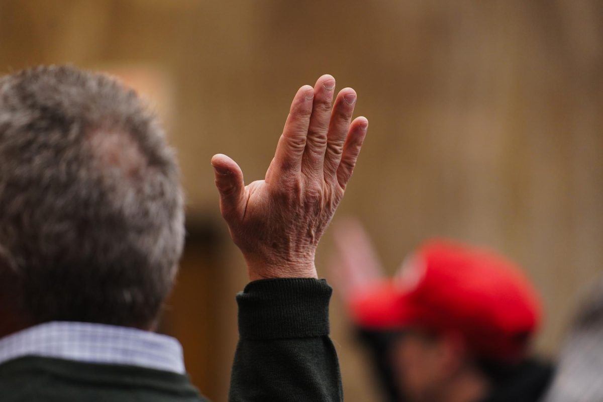 An Ames community member raises their hand while voting for county convention delegates during the 2024 Iowa Republican Caucus, Memorial Union, Jan. 15, 2024. 