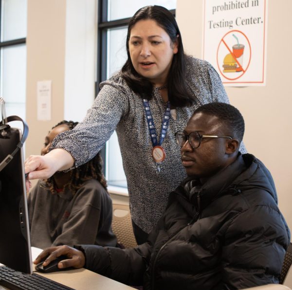 A faculty member helps a student as they try out Workday at the Workday Mock Semester at the Durham Testing Center on Feb. 1, 2024.