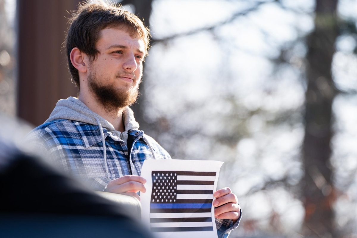 An anonymous student holding a "Blue Lives Matter" flag during the Color of Love protest outside of the Parks Library on Feb. 1, 2024. 