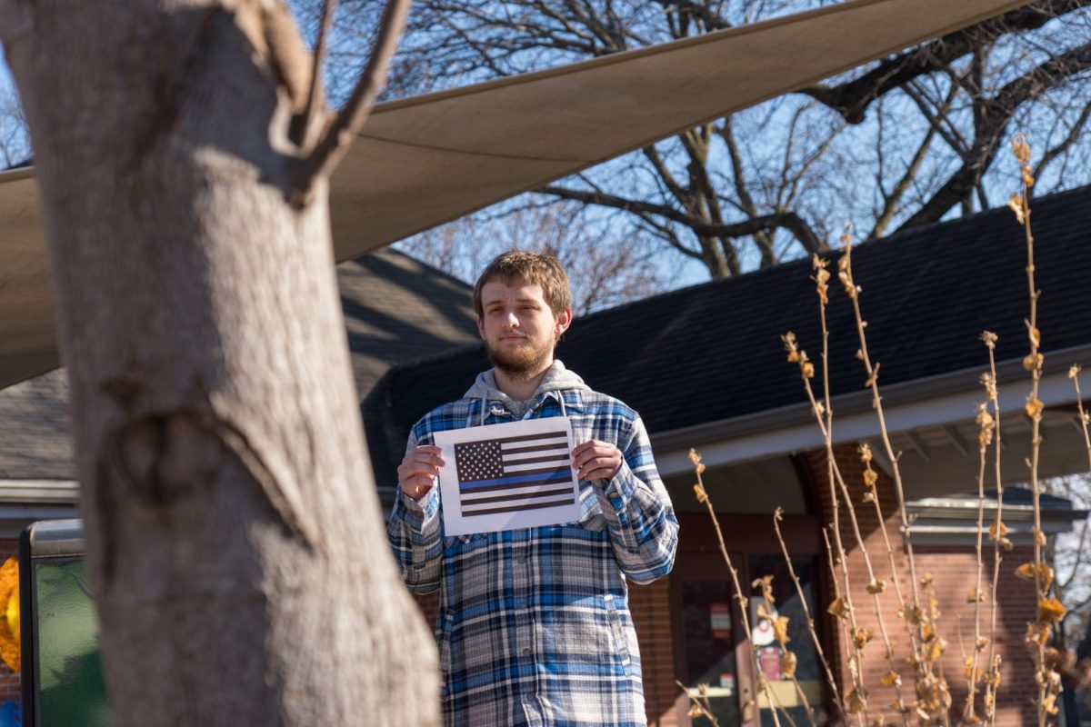An anonymous student holding a Blue Lives Matter flag during the Color of Love protest outside of the Parks Library on Feb. 1, 2024. 
