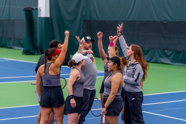 Iowa State womens tennis team throws their hands in the air chanting for a good match against Iowa for the Iowa State vs. Iowa match in Life Time gym located in Urbandale, IA on Feb. 16, 2024.