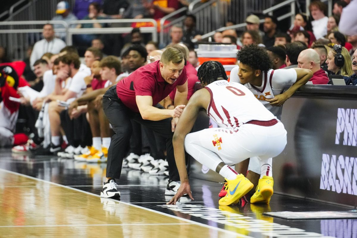 Head Coach T.J. Otzelberger talks with Curtis Jones and Tre King before subbing in the second half of the Big 12 mens basketball tournament game against Kansas State, T-Mobile Center, Kansas City, March 14, 2024.