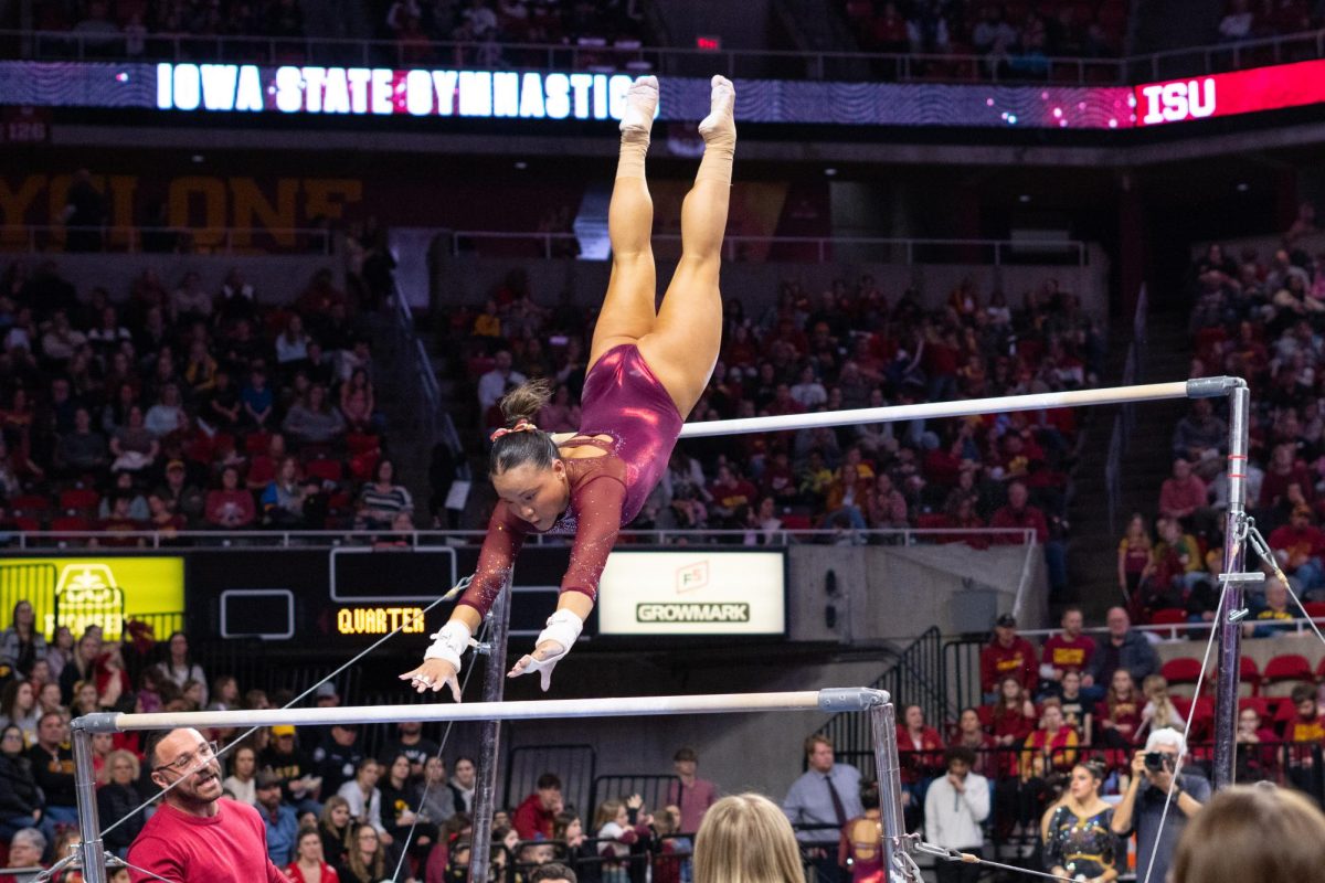 Hannah Loyim transfers between bars during routine as part of the Iowa Corn Cy-Hawk series gymnastics meet against the University of Iowa, Hilton Coliseum, March 8, 2024.