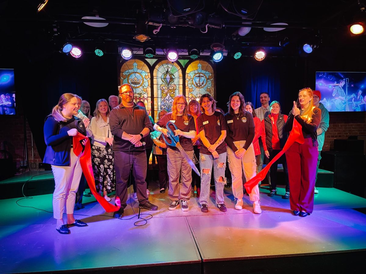 Ames Chamber of Commerce and Maintenance Shop staff stand on stage at the ribbon cutting ceremony on March 19.
