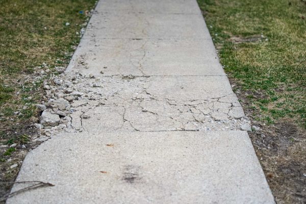 A damaged sidewalk located just outside of apartment building 9 at The Madison apartments on March 7, 2024.