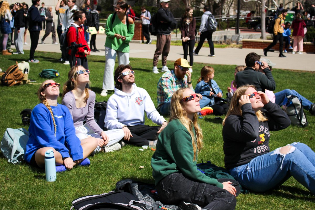 Groups of families and students of Ames Iowa gather to watch the eclipse. Iowa State University Park Library Front Lawn, April 8th 2024.