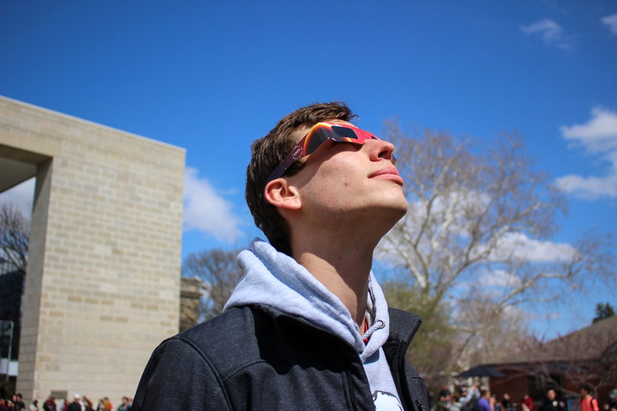 Louis Sosa, geology major, watches as large space rock (the moon) cover the sun. Iowa State University Park Library Front Lawn, April 8th 2024.