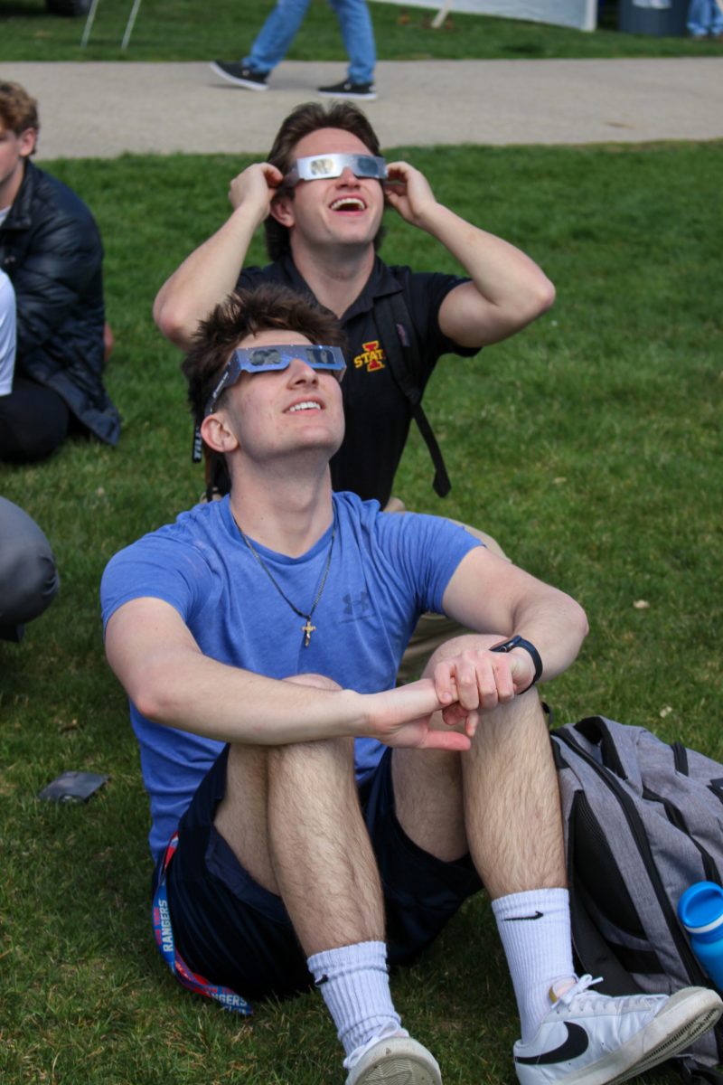 Two college students, John Larounis and Matt Buchich, watch the eclipse with their friends. Iowa State University Central Campus, April 8th 2024.
