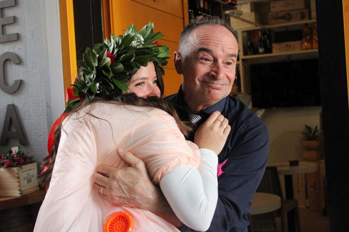 Giovanni Garbugli, owner of Sugar Café and father of Agnese receiving a hug from his daughter, who also works at the café. 