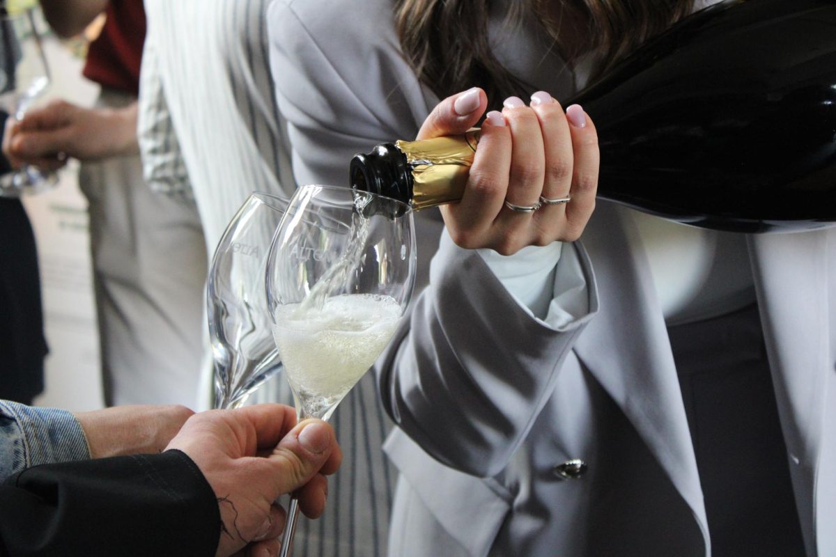 Agnese Garbugli, who travels and works as a bartender, pouring champagne for guests at her graduation party at Sugar Café. 