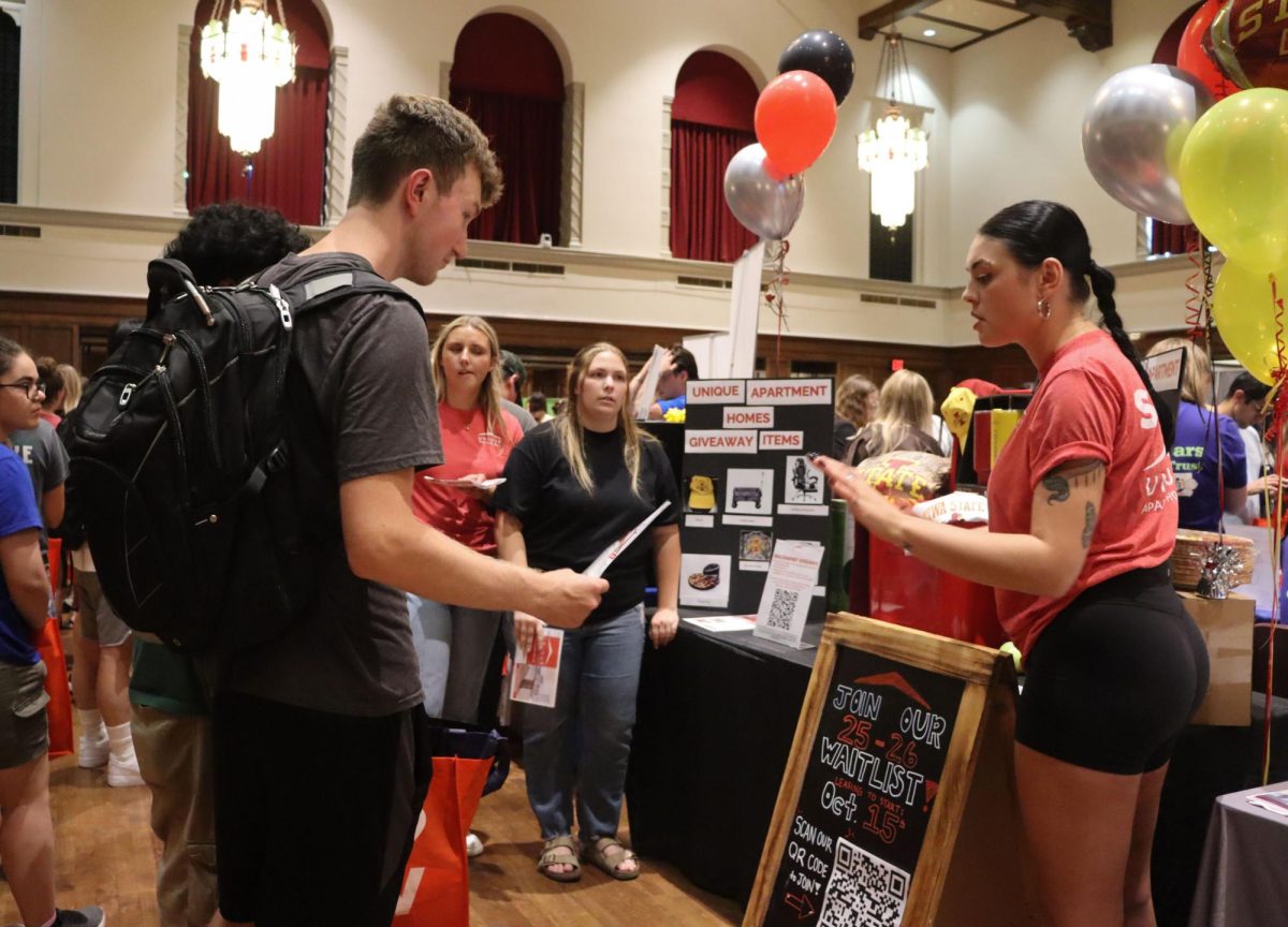 Aidan McGinnis is handed a pamphlet from the table at Unique Apartments at the Welcome Fest on Aug. 28, 2024 at the Memorial Union in Ames. 