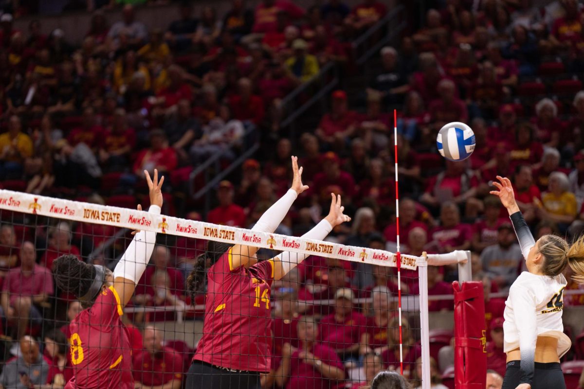 Iowa State attempts to block the ball as part of the Iowa Corn Cy-Hawk series volleyball meet against the University of Iowa, Hilton Coliseum, Sept. 11, 2024.