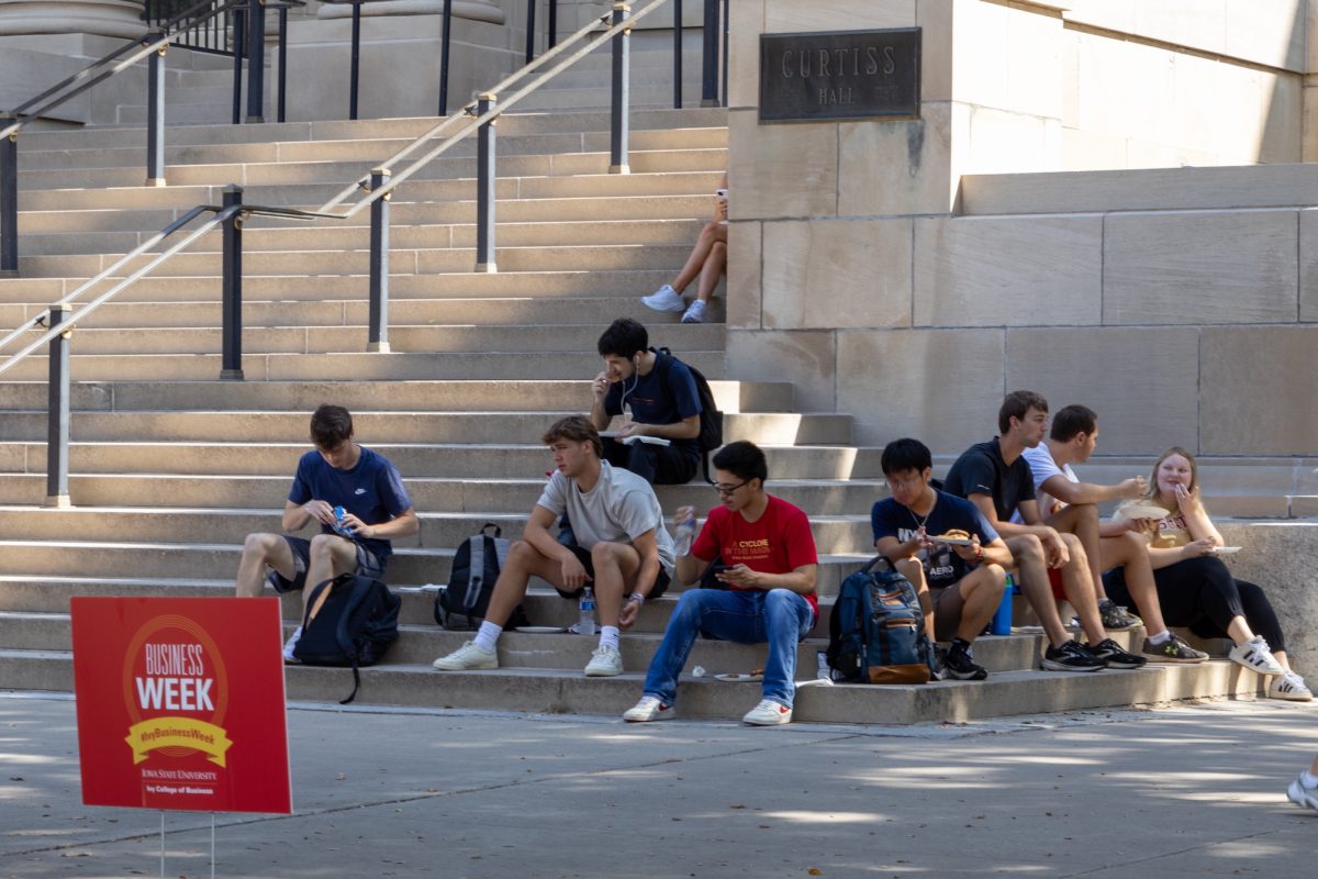 Students sit on the steps of Curtiss Hall and eat a sponsored lunch by Collins Aerospace during Business Week, Sept. 16, 2024, Ames, Iowa.