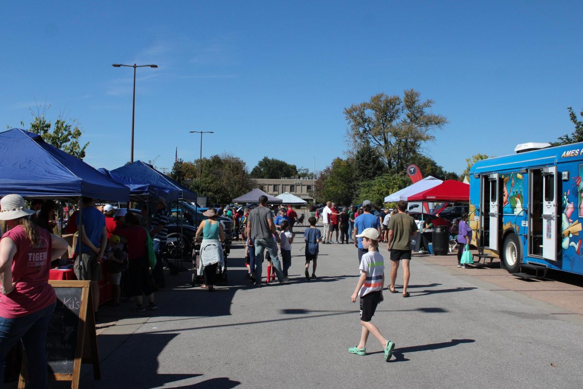 Citizens of Ames walk through the various booths from companies at the EcoFair outside of Ames City Hall, Sept. 28, 2024