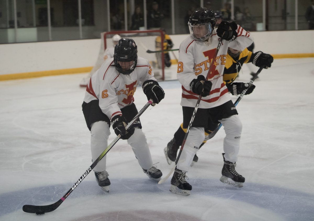 Iowa State's women hockey club player number 6 focused on the puck while passing teammate number 8 versus the University of Iowa women's hockey club at the ISU Ice Arena, Sept. 27, 2024.