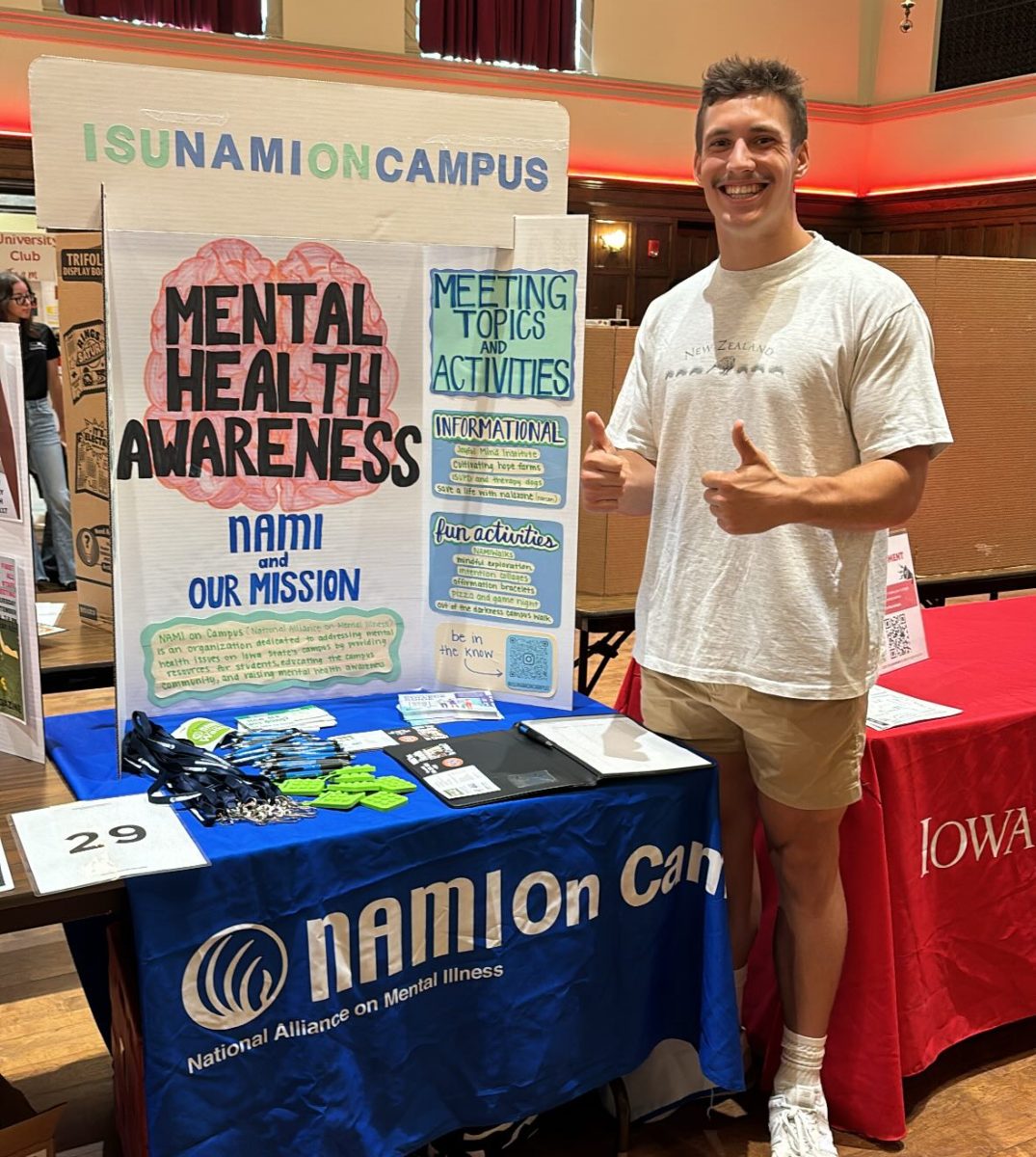 Ben Kujawa poses with a NAMI on Campus mental health poster at Club Fest, September 11, 2024.