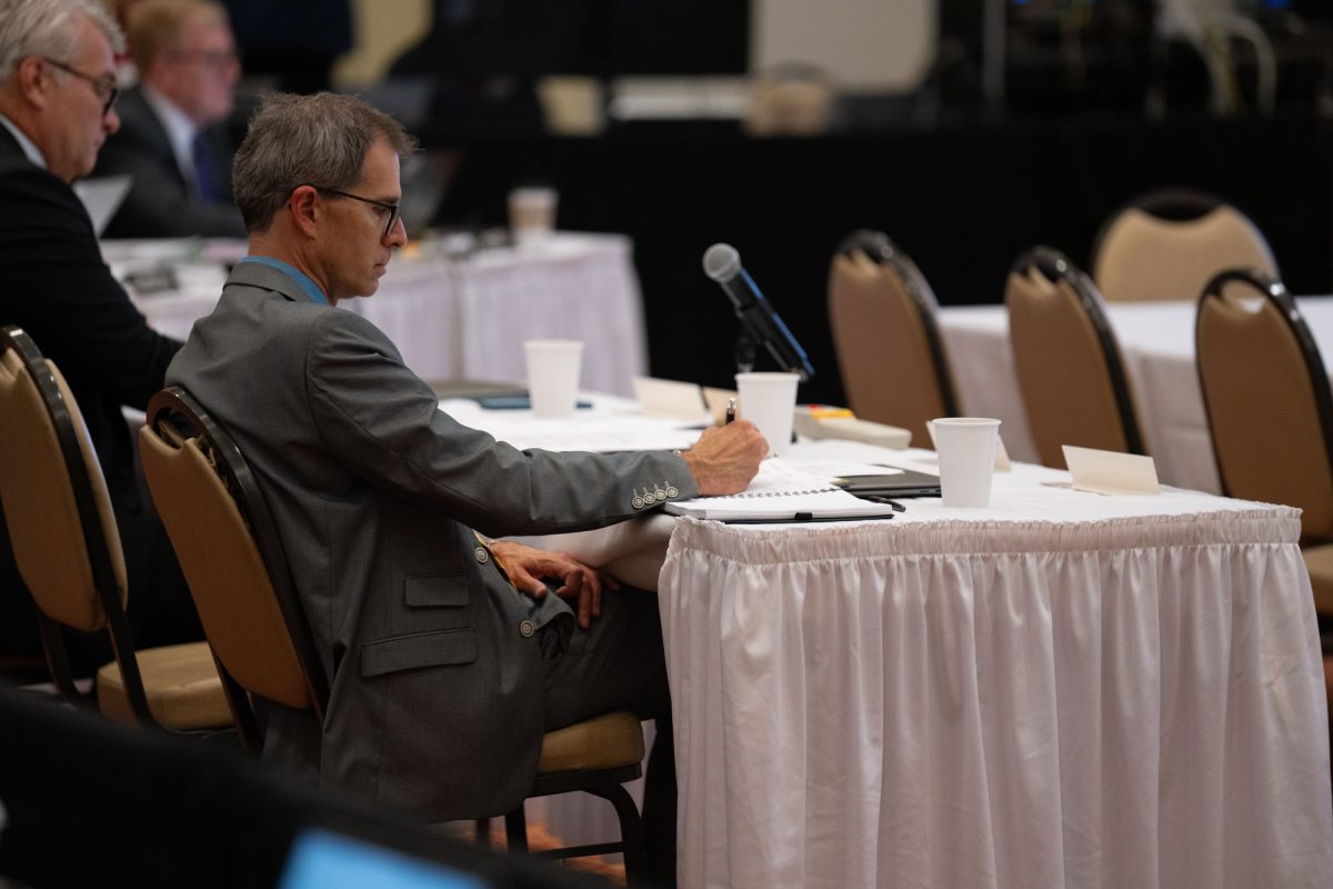 Senior Vice President and Provost Jason Keith writes in their notebook during the Board of Regents meeting at the Alumni Center on Sept. 19, 2024.