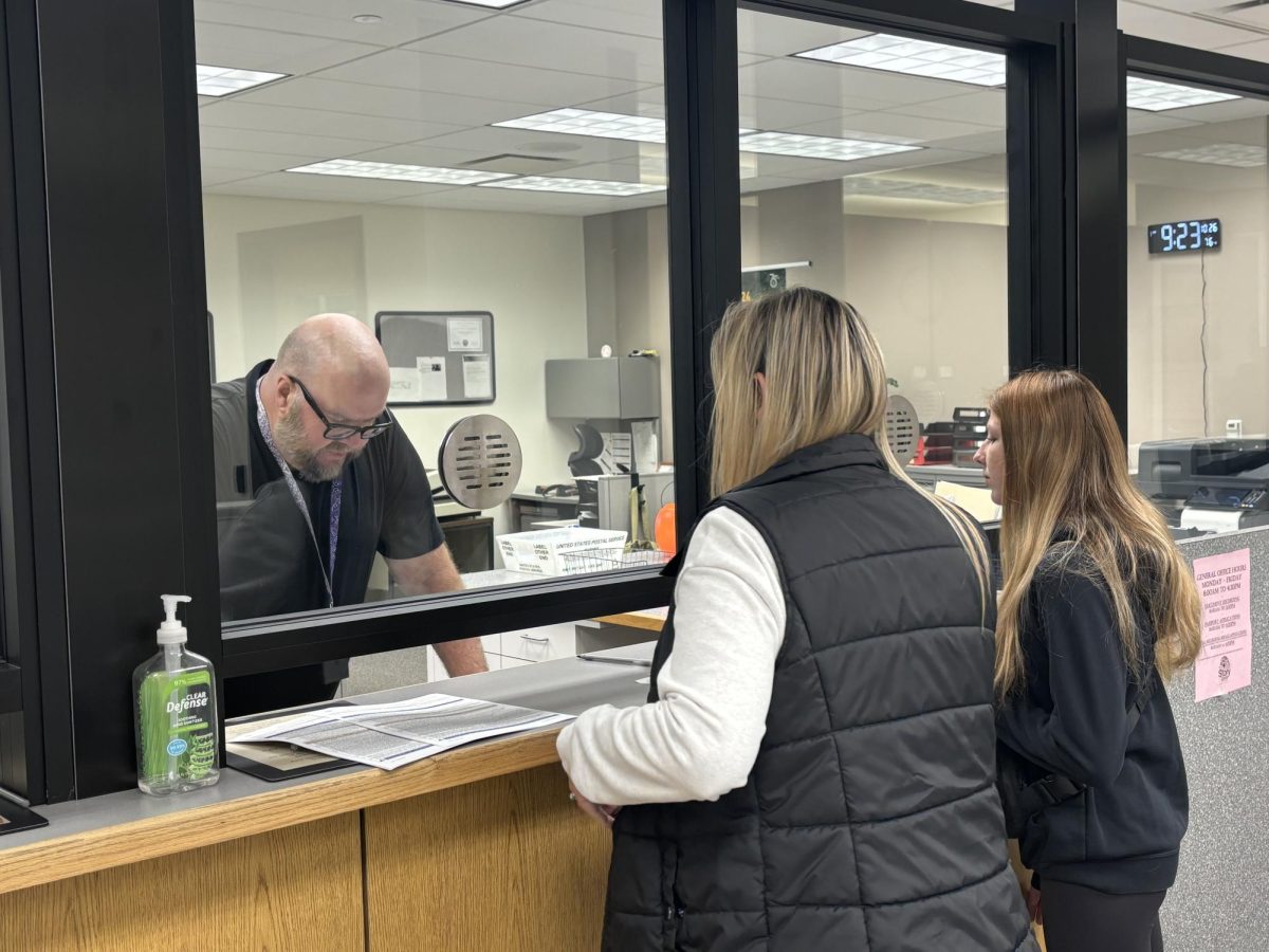 Deputy Recorder Jim Cheek helps a family during passport day at the Story County Recorders Office on Oct. 27, 2024.