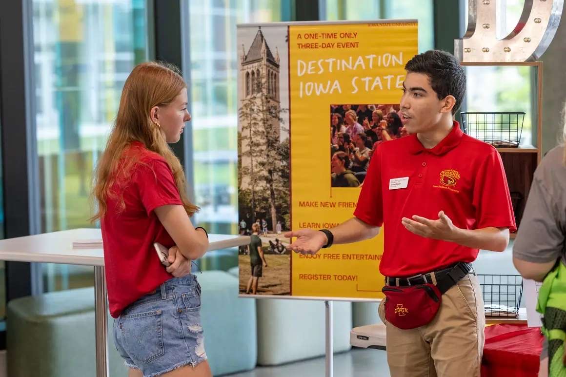 Cyclone Aide, Jordan Edejer helping a student learn about Destination Iowa State