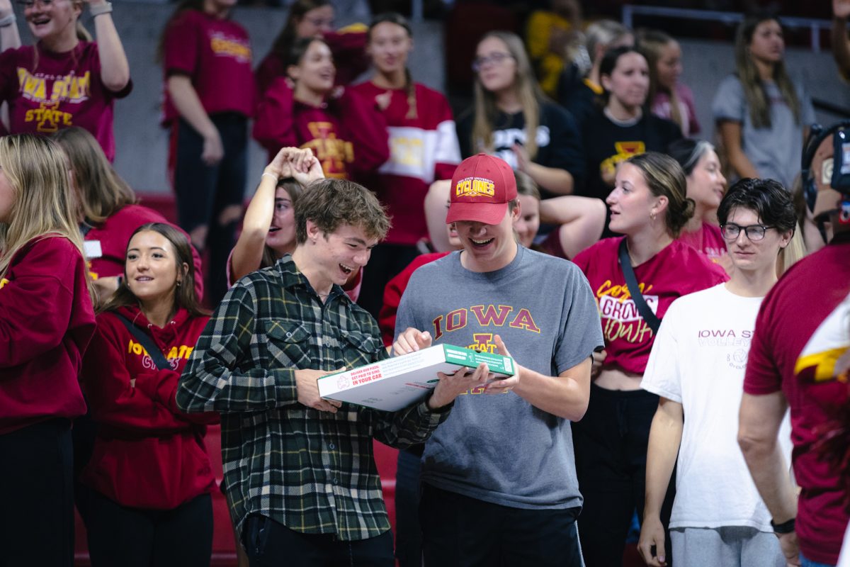 Students Michael Heidt and Will White receiving pizza during the Iowa State vs Cincinnati volleyball game at Hilton Coliseum on Oct. 2, 2024.