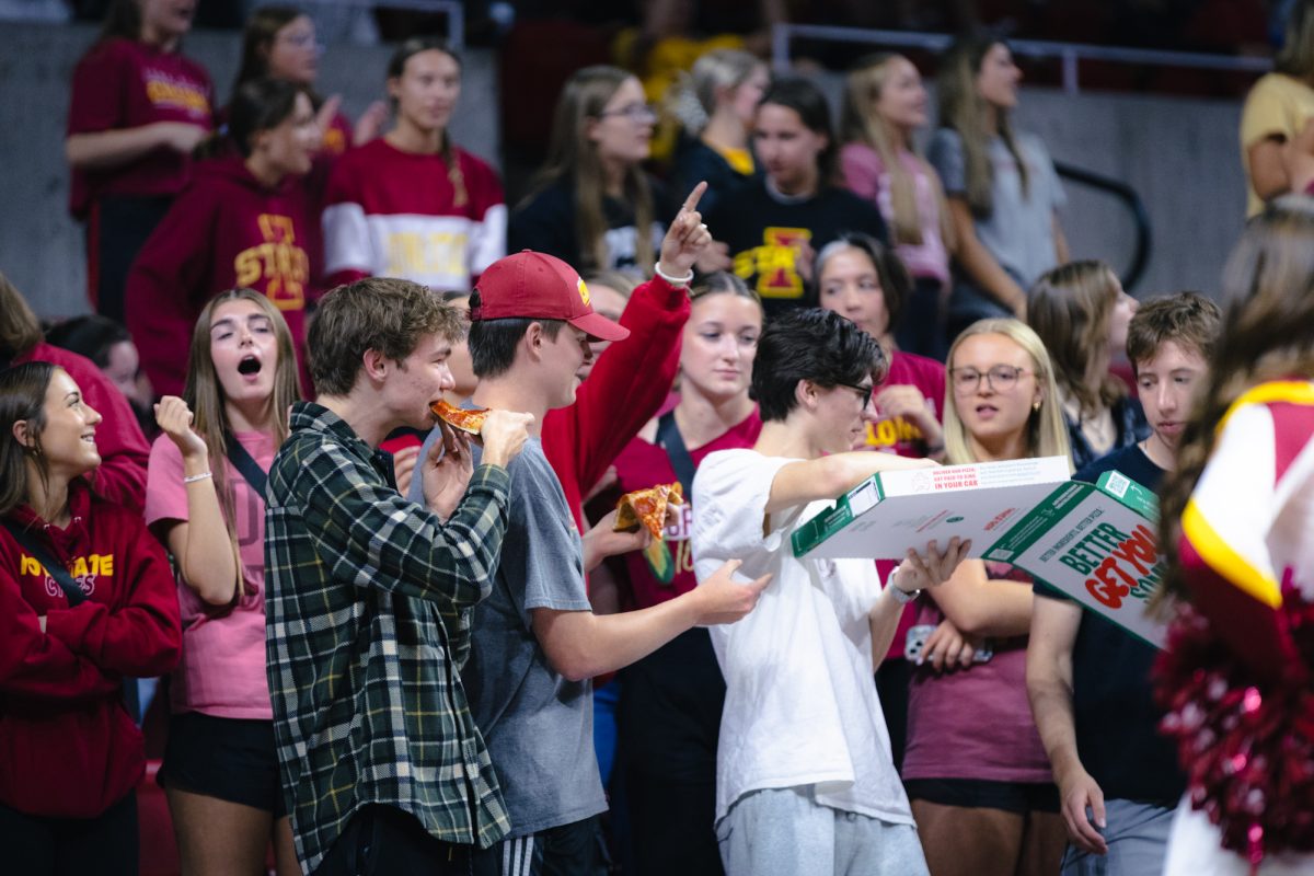 Iowa State students pass out pizza during the Iowa State vs Cincinnati volleyball game at Hilton Coliseum on Oct. 2, 2024.