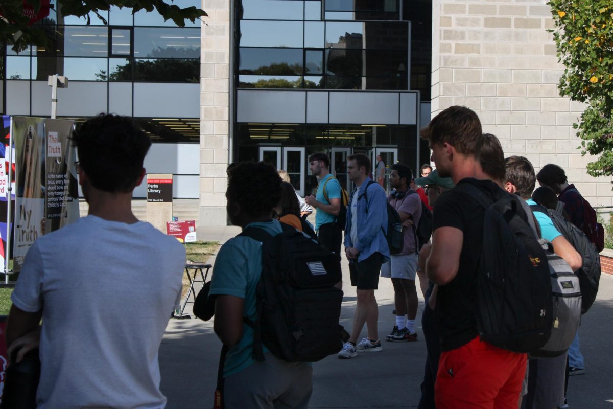 A group of college students listening to Skylar Sowry, part of Campus America, preach outside Parks Library, Oct. 9, 2024.