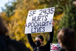 An unnamed Iowa State student holds up a, "SF 2435 Hurts POC&LGBT+ Lives" sign in front of Parks Library, Oct. 24, 2024.