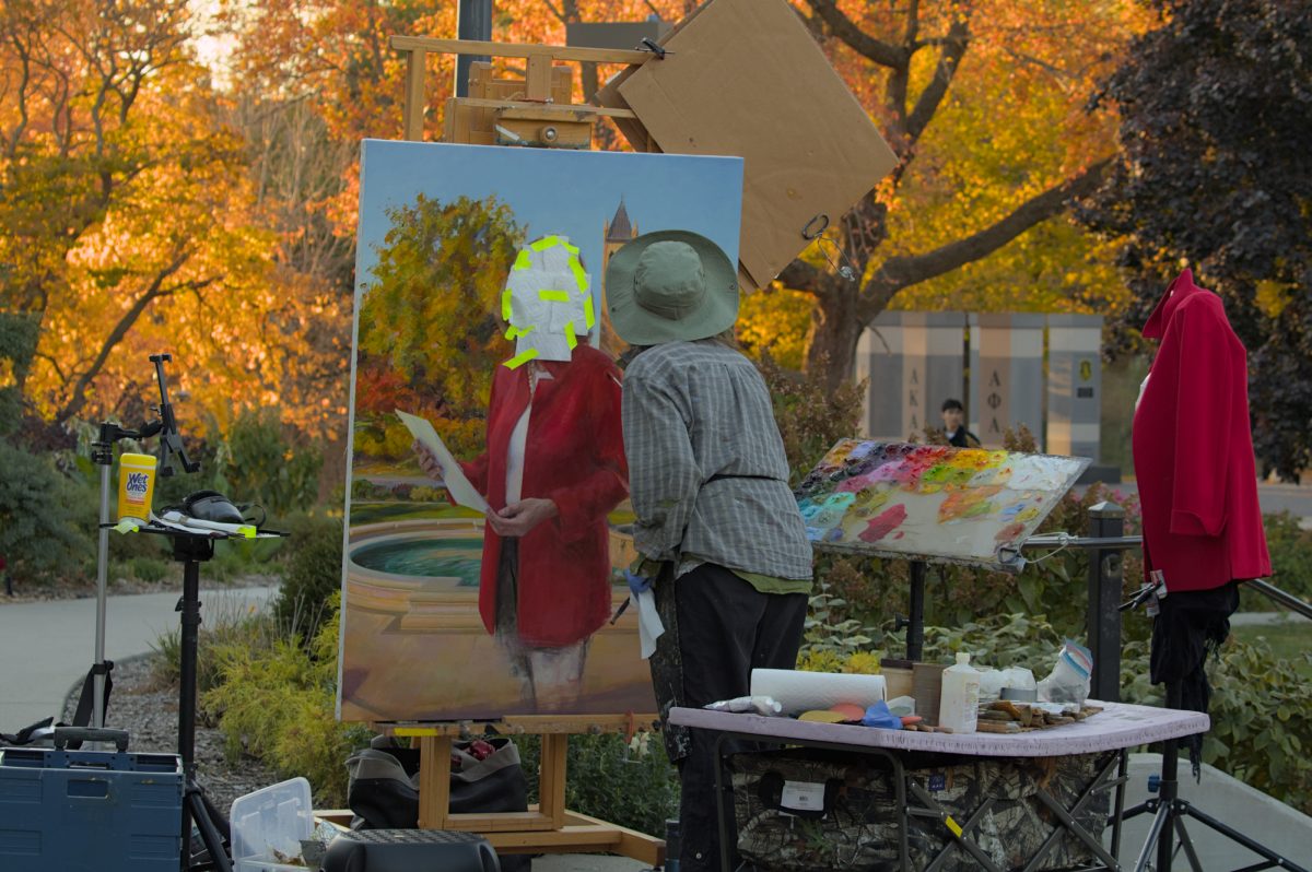 Artist Rose Frantzen paints the eloquent details of Iowa State University President Wendy Wintersteen's jacket, Oct. 23, 2024.