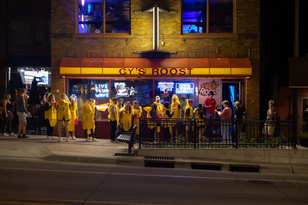 Banana Bar Crawlers smile at the camera while waiting to get into Cy's Roost. Oct. 10, 2024.