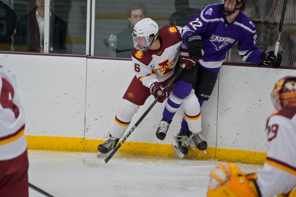 Iowa State Men's Hockey Club player Christopher Kondiles (6) pushes a McKendree University player into the wall during a home game, Oct. 4, 2024.