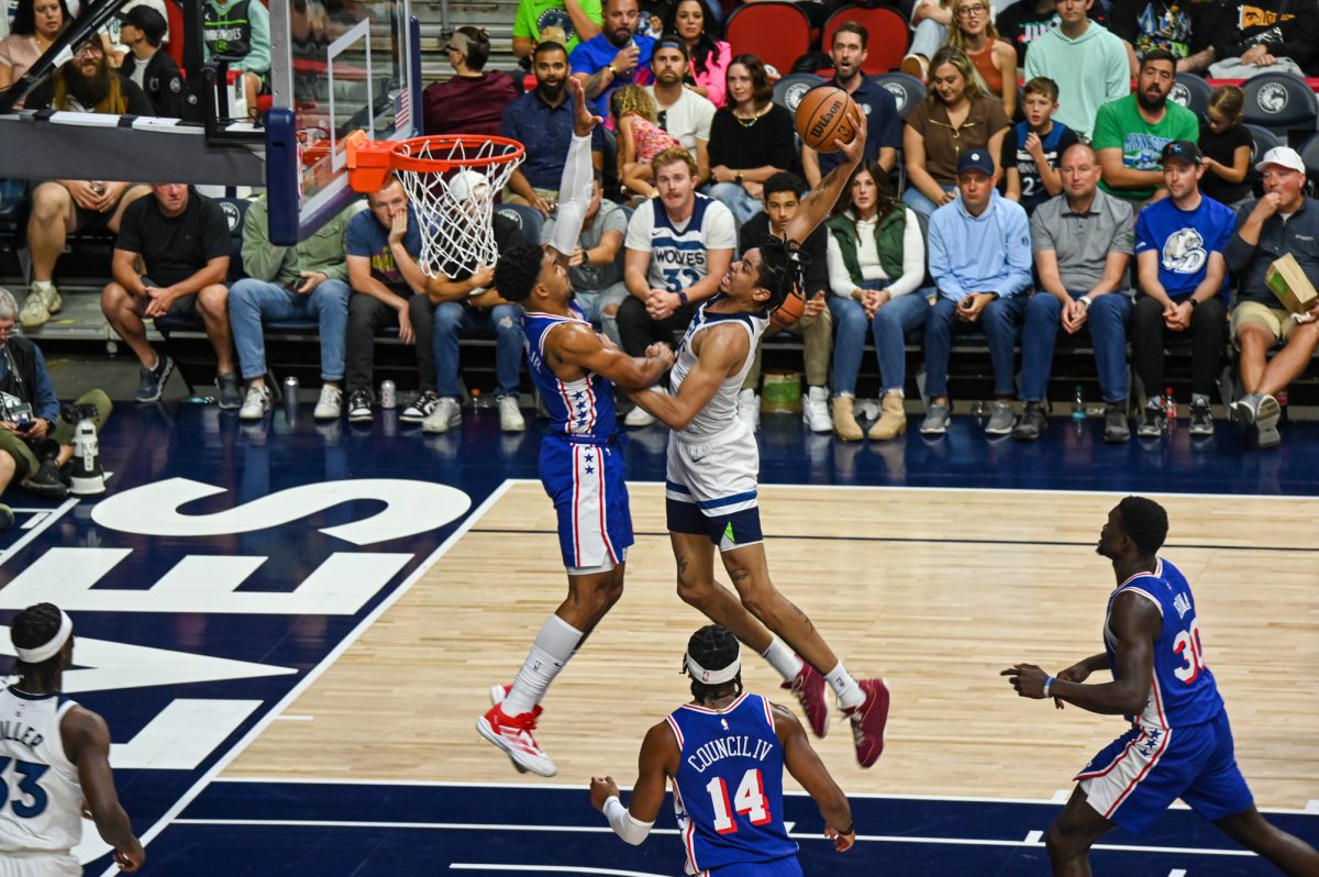 Minnesota Timberwolves player Joch Minott (8) goes to slam the ball through the hoop while Philadelphia 76ers player KJ Martin (1) blocking him during a preseason game in Des Moines Iowa at Wells Fargo Arena, Oct. 11, 2024.