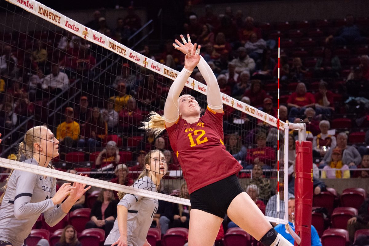 Emily Bobbitt (12) reaches to tip the ball over the net during the game vs. University of Colorado, Hilton Coliseum, Ames, Iowa, Nov. 13, 2024.