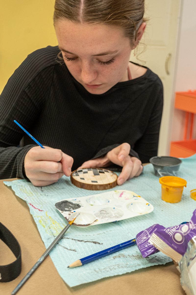 Iowa State student Carly Wiegel paints her wooden piece as a disco ball in the MU Maker Space, Nov. 4, 2024.