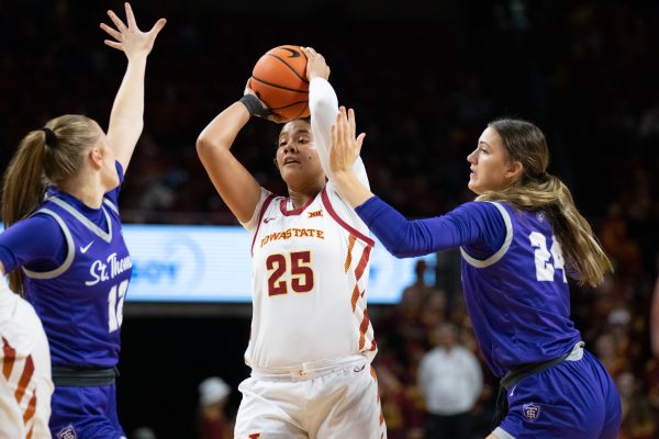 Sydney Harris (25) looks to pass the ball while being guarded by Mikayla Werner (12) and Alyssa Sand (24) during the game vs. University of St. Thomas, Hilton Coliseum, Ames, Iowa, Nov. 14, 2024. 