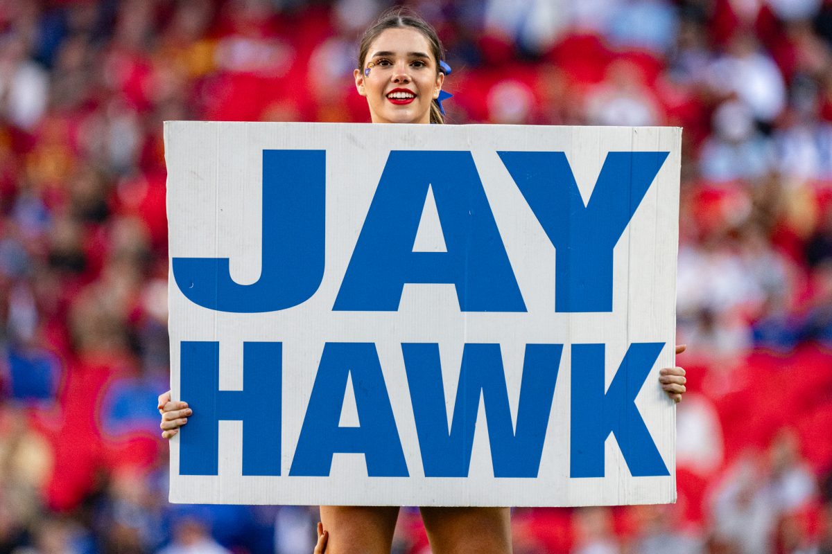 A member of the University of Kansas Spirit Squad holds up a Jay Hawk sign during the Iowa State vs. University of Kansas football match on Nov. 9, 2024 on GEHA Field at Arrowhead Stadium.