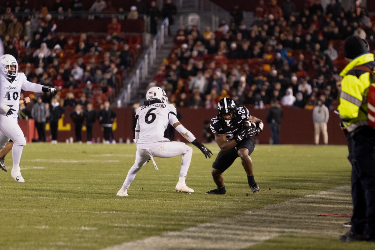 Abu Sama III (24) catches and attempts to run with the ball past Trevon Gola-Collard (6) during the Iowa State Cyclones and Cincinnati Bearcats game in Ames Iowa on Nov. 16, 2024.