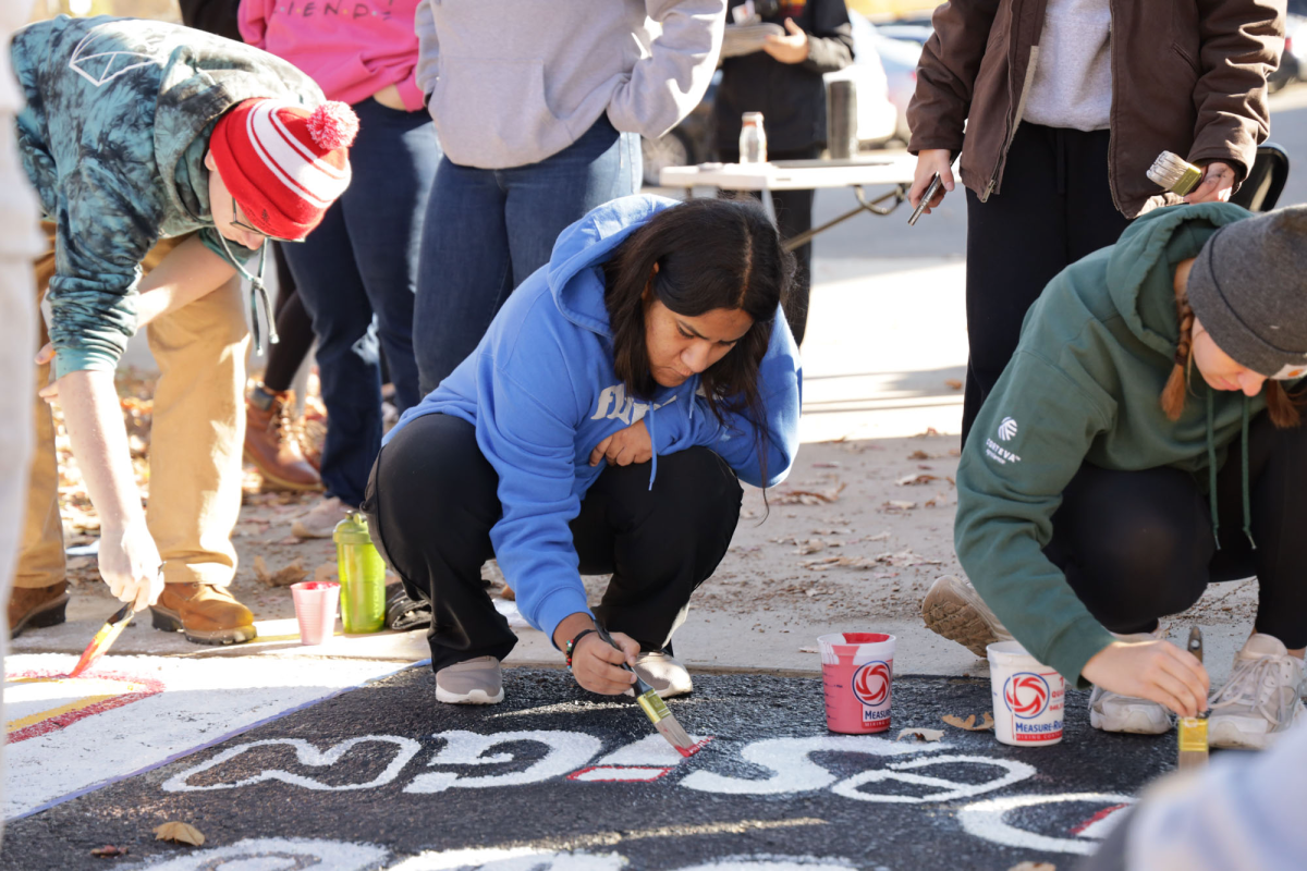 Andrea Trejo paints a square with Women Who Design. Members of more than 20 student organizations painted squares on "Victory Lane" on Sunday, Oct. 27, 2024. Gabrielle Townsend, a member of the Student Alumni Leadership Council, said, "It's a really fun tradition we've had for a long time." Victory Lane was moved closer to Jack Trice Stadium this year, in hopes of making it more accessible to fans attending the Homecoming game.