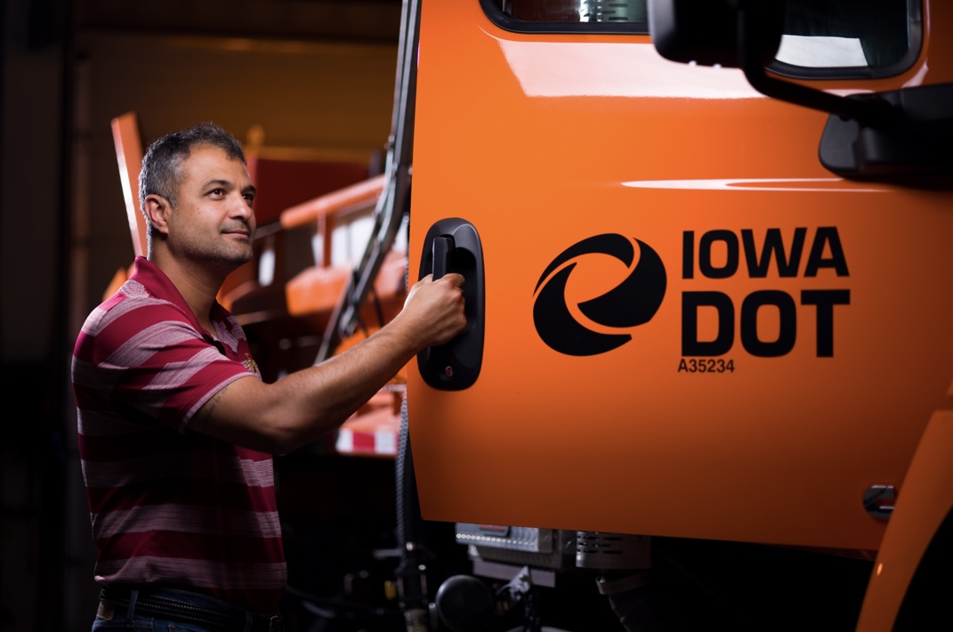 Anuj Sharma poses with an Iowa Department of Transportation snow plow. Photo courtesy of Anuj Sharma.